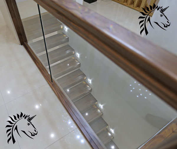 Milan black walnut staircase with landing glass balustrade.