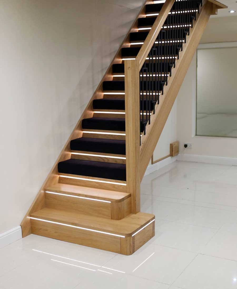 Manhattan oak staircase with black balusters and integrated LED lighting by Stairplan