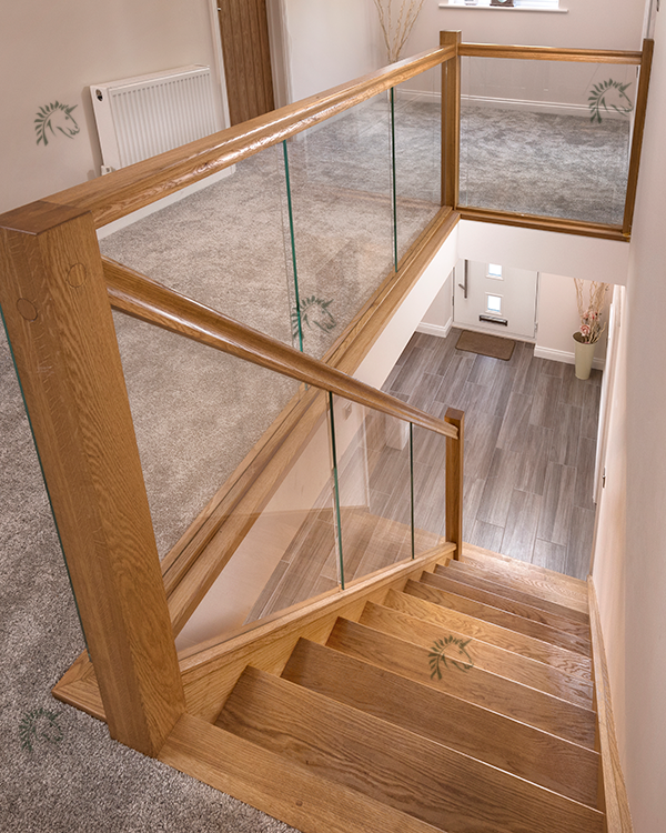 Recessed Vision glass balustrade with oak handrail and newel posts